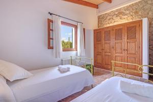a bedroom with two beds and a window at Villa Joana in Pollença +19 photos