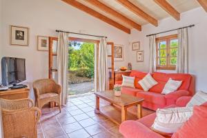 a living room with a red couch and a tv at Villa Joana in Pollença
