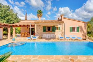 a villa with a swimming pool in front of a house at Villa Joana in Pollença