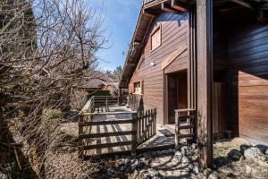 a wooden house with a staircase leading to the door at Chalet 6p Confort - Le bouvreuil in Verchaix