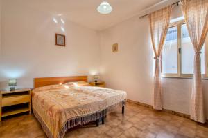 a bedroom with a bed and a window at Veranda Vista Mare Isola Rossa in Isola Rossa