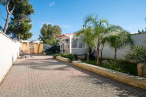 a brick driveway in front of a white house at Elenya Garden Retreat in Torre Lapillo +15 photos