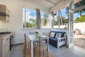 a kitchen and dining room with a table and chairs at Elenya Garden Retreat in Torre Lapillo