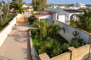a house with a walkway and palm trees at Elenya Garden Retreat in Torre Lapillo