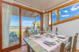 a dining room with a table and a balcony at 4 Appartamento Cala Brandinchi in San Teodoro