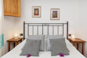 a bedroom with a bed with gray pillows on it at 4 Appartamento Cala Brandinchi in San Teodoro +16 photos