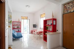 a living room with a red cabinet and a table at Villa Verde - 300m From Sea in Bordighera