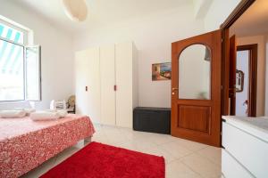a bedroom with a bed and a red rug at Villa Verde - 300m From Sea in Bordighera