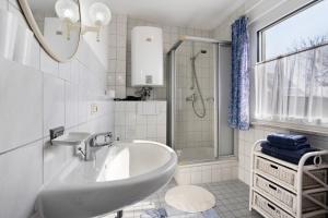 a white bathroom with a sink and a shower at Haus Zapf in Kressbronn am Bodensee +30 photos