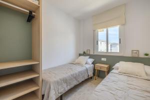 ein Schlafzimmer mit zwei Betten und einem Fenster in der Unterkunft Las Conchas in Cunit + 16 Fotos