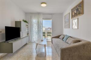 ein Wohnzimmer mit Sofa und Fernseher in der Unterkunft Las Conchas in Cunit