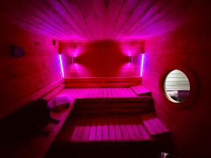 a room with pink lights in a room with a window at Kleines Eifel Backhaus mit Sauna in Feuerscheid