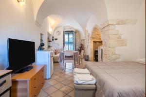 a bedroom with a bed and a tv in a room at Dimora La Piana in Ostuni