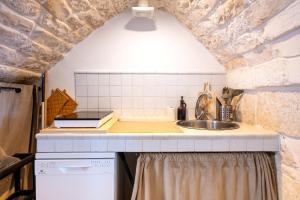 a kitchen with a sink and a brick wall at Dimora La Piana in Ostuni +20 photos