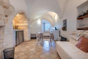 a kitchen and living room with a table and a couch at Dimora La Piana in Ostuni