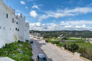 a street next to a white building on a hill at Dimora La Piana in Ostuni