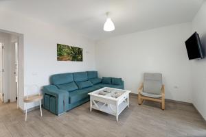 a living room with a blue couch and a table at Casa Elvira in Frontera