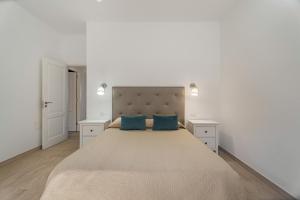 a bedroom with a large bed with two blue pillows at Casa Elvira in Frontera