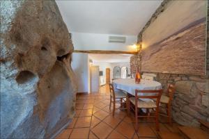 a dining room with a table and a stone wall at Villa Roccia in Porto Rotondo