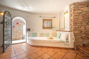 a bedroom with a bed and a stone wall at Villa Roccia in Porto Rotondo +32 photos