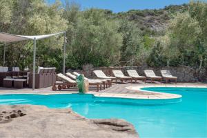a pool with chaise lounge chairs and a swimming pool at Villa Roccia in Porto Rotondo