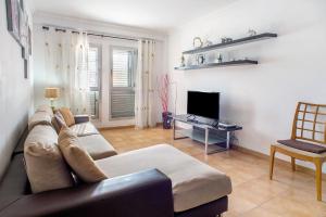 a living room with a couch and a television at Playa Sardina in Gáldar