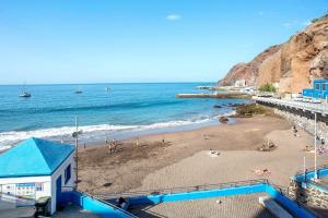 a beach with people on the sand and the ocean at Playa Sardina in Gáldar