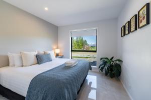 a white bedroom with a large bed and a window at 2BR Guest Retreat in Country Home with Shared Hallway in Tarras