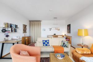 a living room with a white couch and orange chairs at Schönblick in Höchenschwand