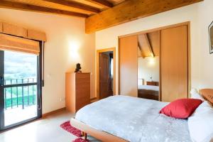 a bedroom with a large bed and a large window at Juanikoenea in Leitza