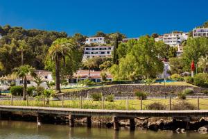 a bridge over a river with buildings in the background at Villa Lidia in Cala Galdana