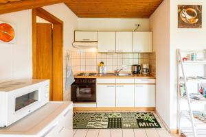 a kitchen with white cabinets and a green and white floor at Jonagold in Stockach