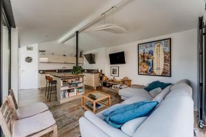 a living room with a white couch and a kitchen at La Villa Sanson in Arcachon