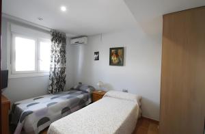 a bedroom with two beds and a window at Villa María Magdalena in Cambrils