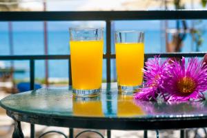two glasses of orange juice and a flower on a table at Nikiana Club - Studio 4 in Nikiana +13 photos