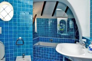a blue tiled bathroom with a sink and a mirror at Villa Ibiscus in Porto Rafael +31 photos
