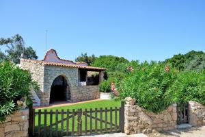 a gate to a stone house with a fence at Villa Ibiscus in Porto Rafael