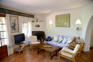 a living room with a couch and a tv at Villa Ibiscus in Porto Rafael