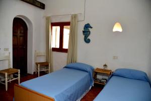 a bedroom with two beds and a window at Villa Ibiscus in Porto Rafael