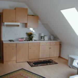 a kitchen with wooden cabinets in a attic at Haus Lechner in Cuxhaven