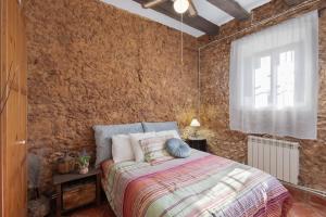a bedroom with a bed and a brick wall at Les Orenetes casa rural in Sant Jaume dels Domenys +31 photos