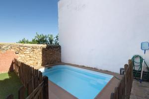 a swimming pool in the corner of a house with a wall at Les Orenetes casa rural in Sant Jaume dels Domenys