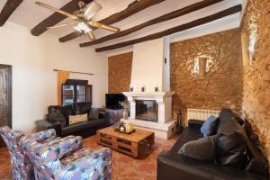 a living room with couches and a fireplace at Les Orenetes casa rural in Sant Jaume dels Domenys