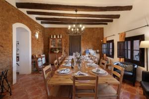 a dining room with a long wooden table and chairs at Les Orenetes casa rural in Sant Jaume dels Domenys