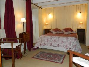 a bedroom with a bed and a table and a chair at La Maison De Marie in Murat