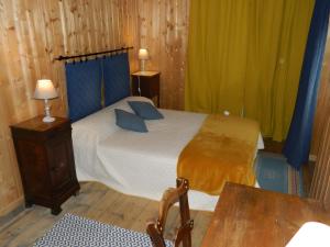 a bedroom with a bed and a table and a chair at La Maison De Marie in Murat +4 photos