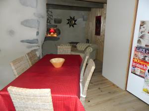 a dining room with a red table and chairs at La Maison De Marie in Murat