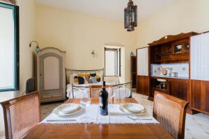 a dining room table with a bottle of wine on it at Mono Scilla Centro Storico Otranto in Otranto