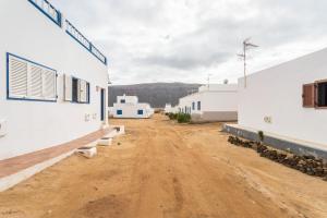 an empty dirt road between buildings in a town at El Sombrerito 6 in Caleta de Sebo +11 photos