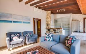 a living room with two blue chairs and a kitchen at Cala Deia in Deia
